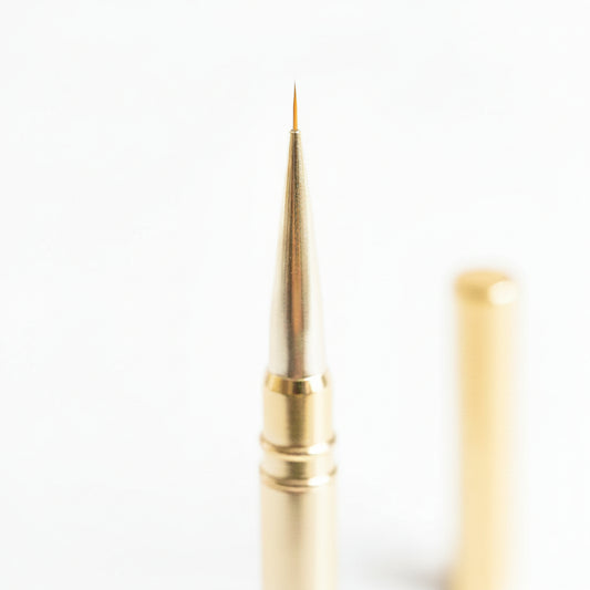 Pinceau liner doré nail art pointe ultra-fine 6mm avec capuchon de protection, manche doré élégant sur fond blanc.