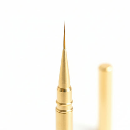 Gros plan sur la pointe fine de 9mm du pinceau liner doré nail art avec capuchon de protection